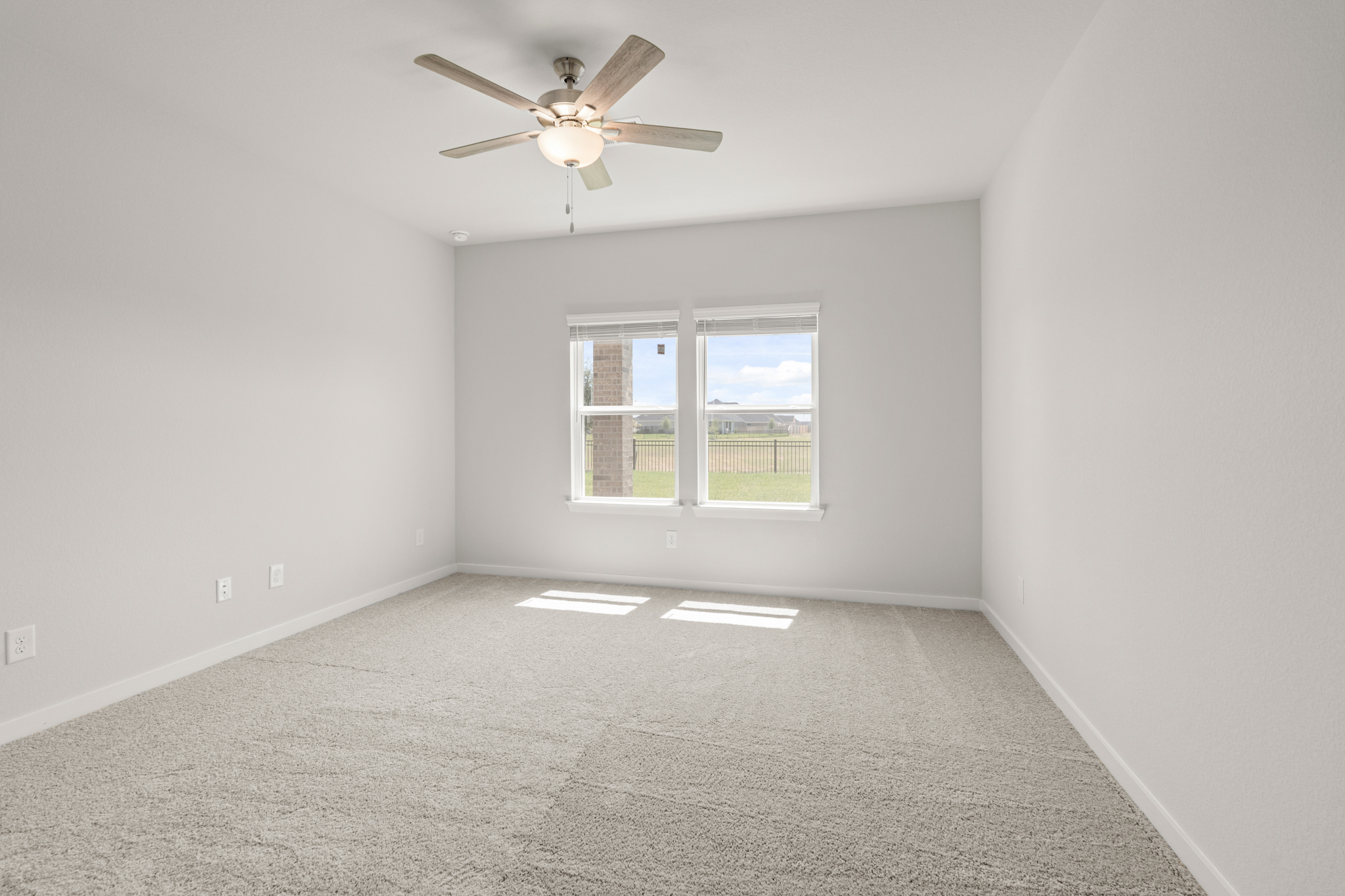 A room with a ceiling fan and a window.