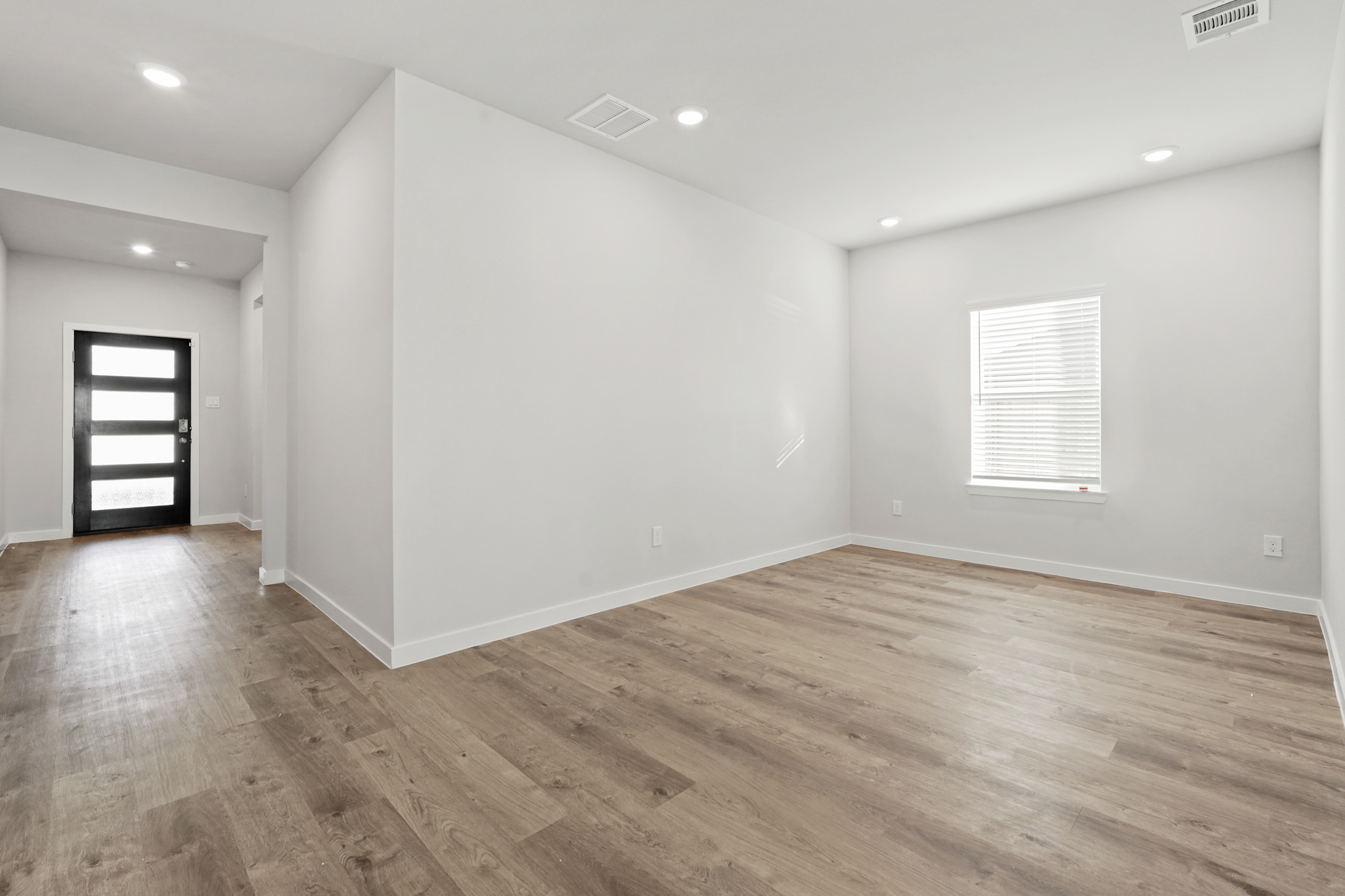A room with a wood floor and white walls.