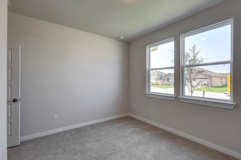 A room with windows and a carpet.