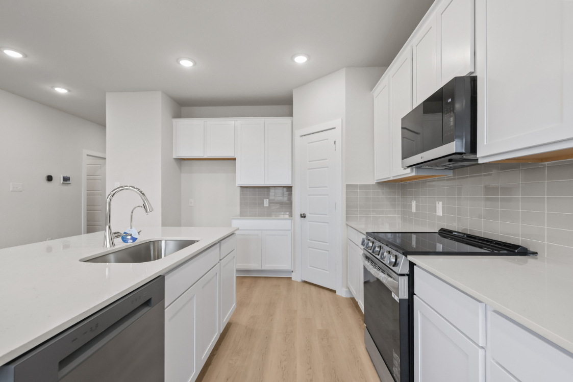 A kitchen with white cabinets.