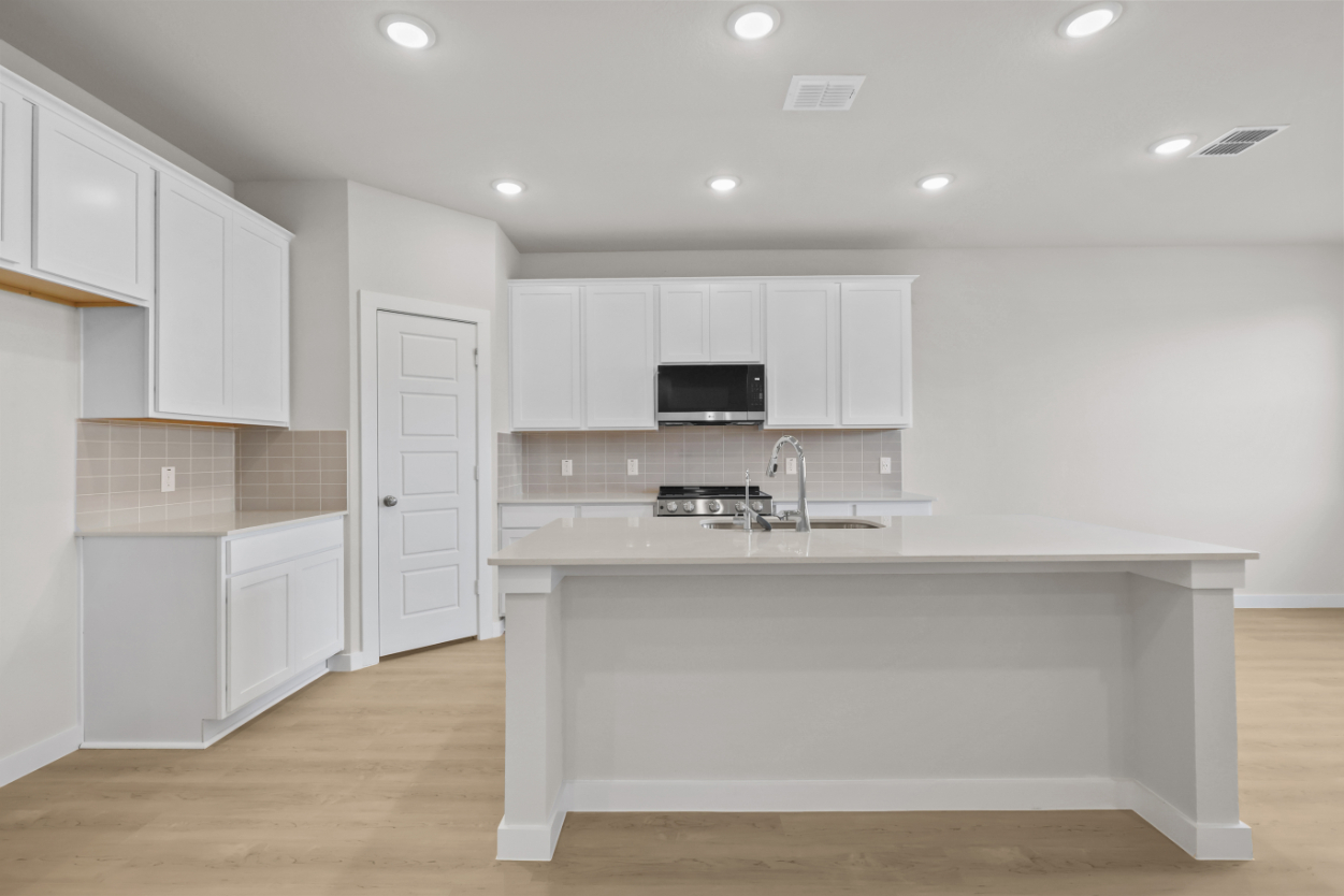 A kitchen with white cabinets.