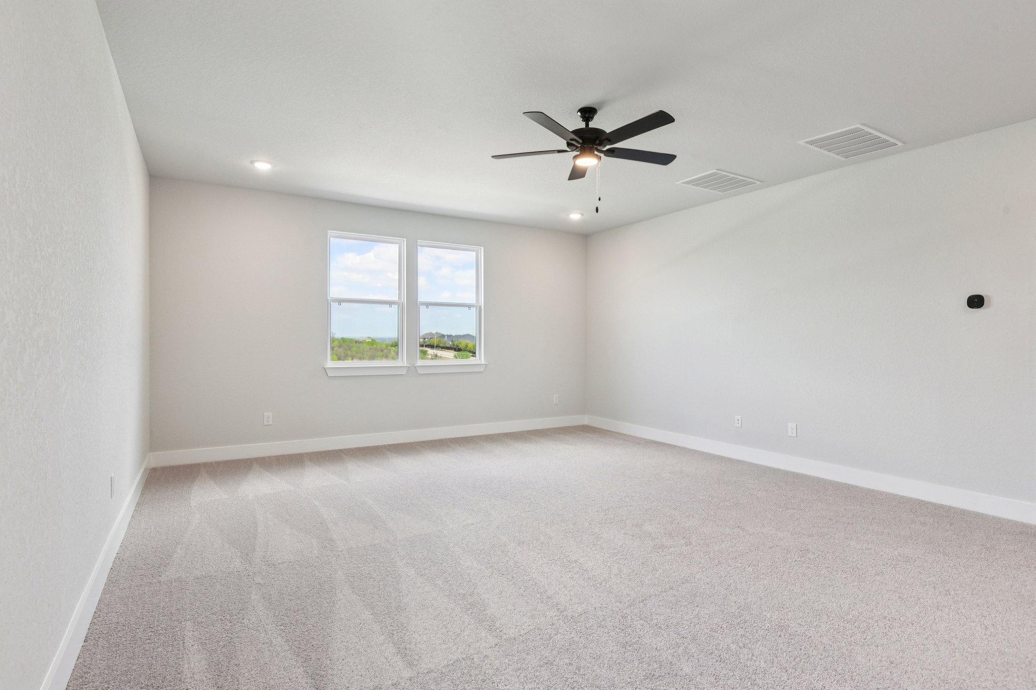 A room with a ceiling fan and a window.
