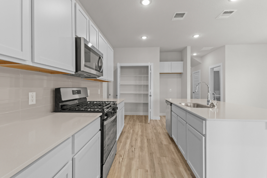 A kitchen with white cabinets.