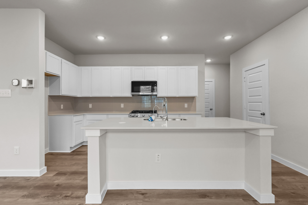 A kitchen with white cabinets.