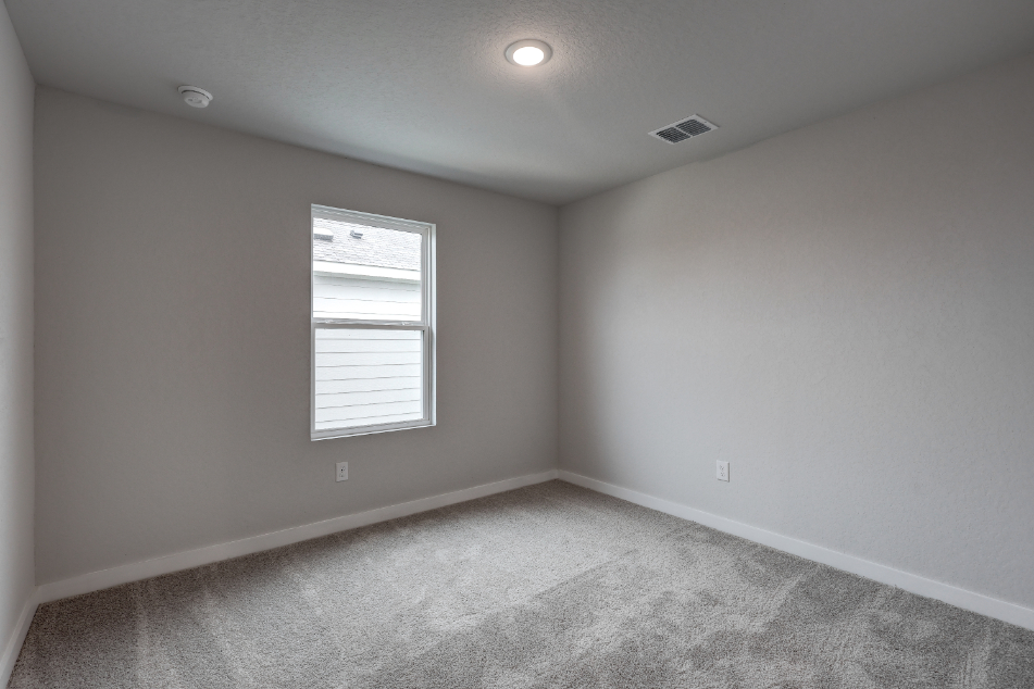 A room with a window and a carpet.