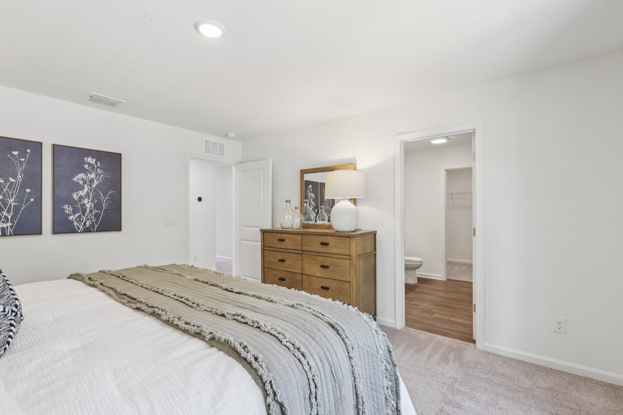 A bedroom with a bed and dresser.