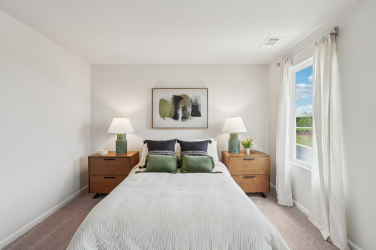 A bedroom with a bed and lamps.