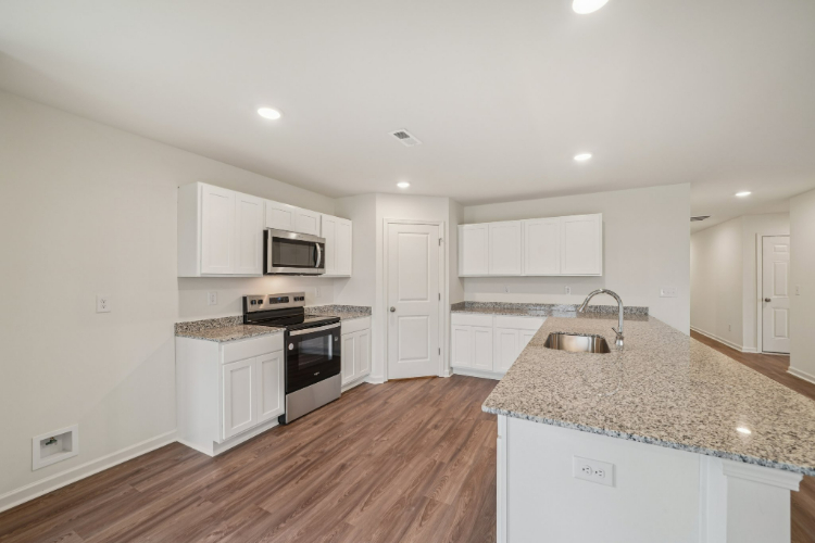 A kitchen with white cabinets.