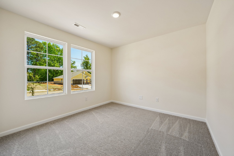 A room with a window and a carpet.