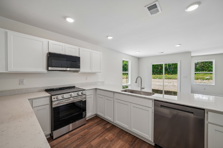 A kitchen with white cabinets.