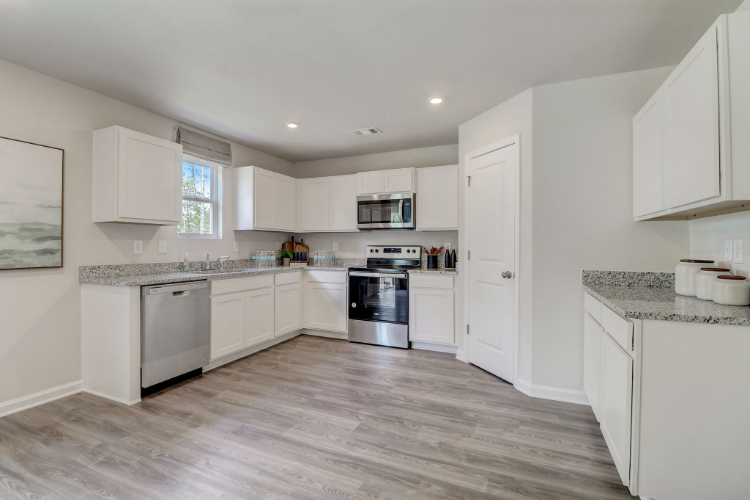 A kitchen with white cabinets.