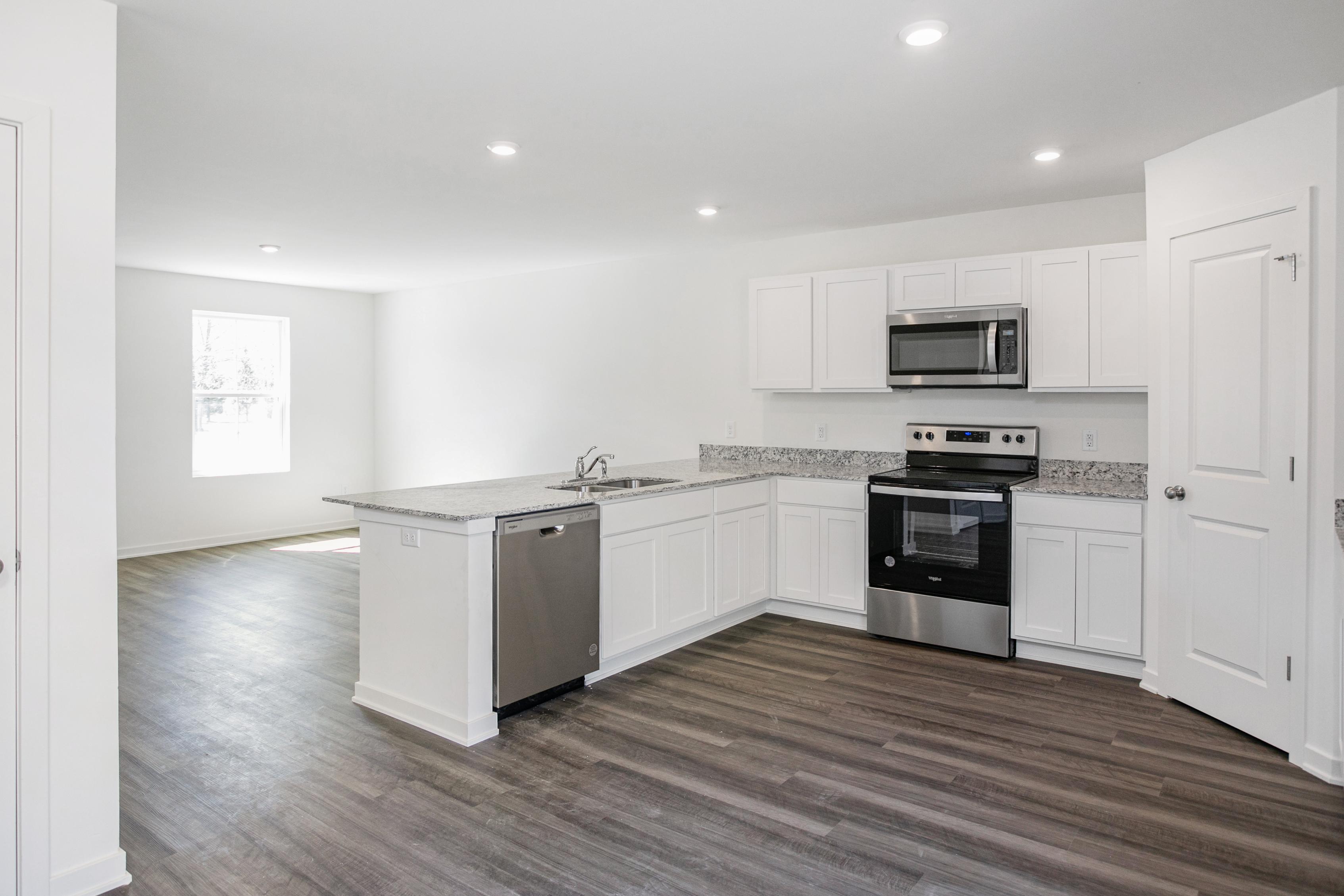 A kitchen with white cabinets.