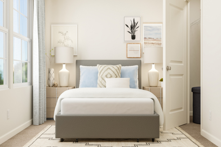 A white bed with blue pillows.